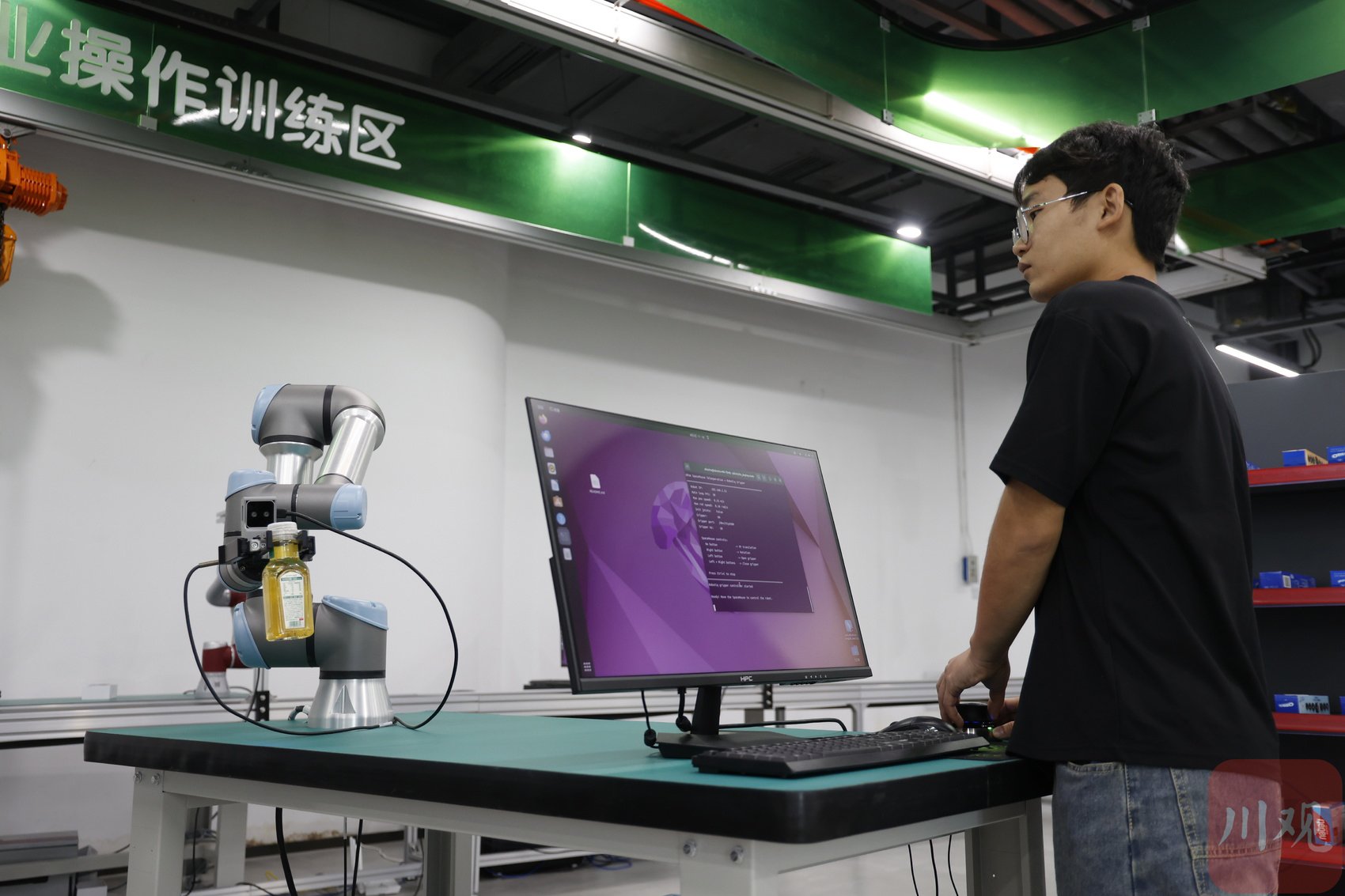 工业操作训练区，机械臂模拟工厂流水线物料抓取作业。